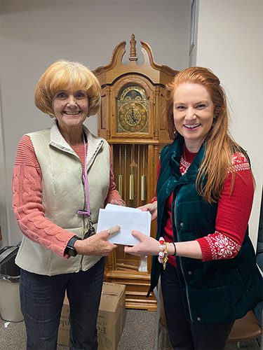 Blog - Alexis Burns at Liberty Towers Handing Cards to a Woman